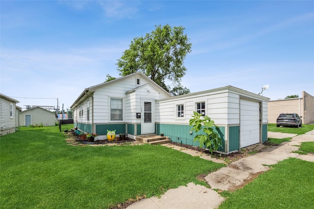 705 Prairie St, Adel, IA 50003 - view of front of property with a front yard, a garage, and an outbuilding