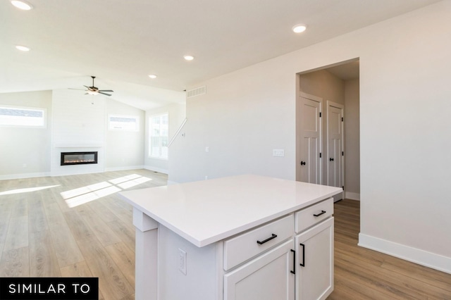1425 Locust St, Waukee, IA 50263 - kitchen with ceiling fan, light wood finished floors, white cabinets, a center island, and light countertops