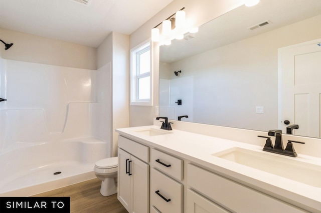1425 Locust St, Waukee, IA 50263 - bathroom with a shower, double vanity, and wood finished floors