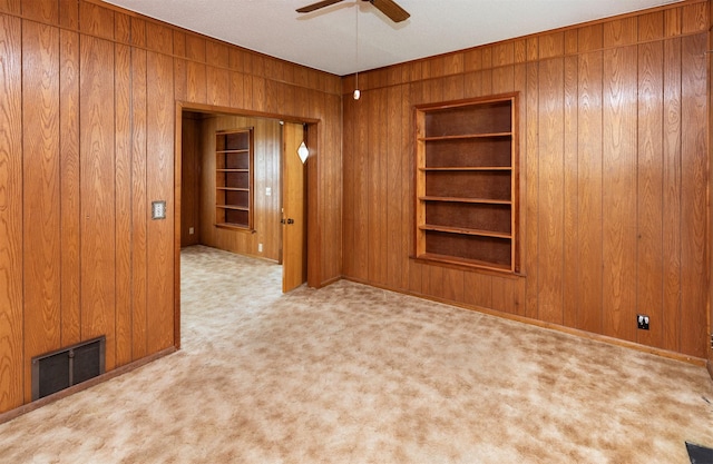 931 Pleasant View Dr, Des Moines, IA 50315 - empty room with wooden walls, a ceiling fan, carpet floors, and built in shelves