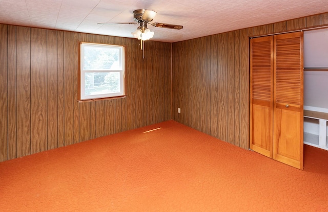 931 Pleasant View Dr, Des Moines, IA 50315 - unfurnished bedroom with wood walls, a closet, carpet, and ceiling fan