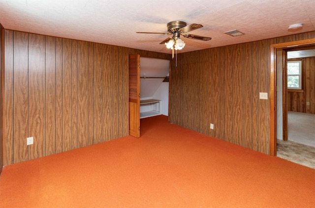 931 Pleasant View Dr, Des Moines, IA 50315 - carpeted empty room featuring wood walls, a smoke detector, and ceiling fan