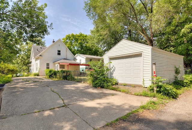 931 Pleasant View Dr, Des Moines, IA 50315 - view of side of home with an outdoor structure, a detached garage, a chimney, and driveway