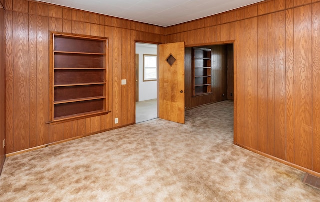 931 Pleasant View Dr, Des Moines, IA 50315 - spare room with wood walls, carpet floors, and built in shelves