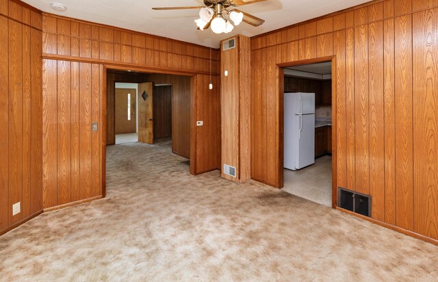931 Pleasant View Dr, Des Moines, IA 50315 - spare room featuring wood walls, a ceiling fan, carpet floors, and ornamental molding