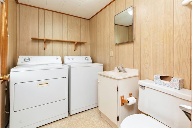 931 Pleasant View Dr, Des Moines, IA 50315 - laundry area with washer and clothes dryer, wood walls, light flooring, and ornamental molding