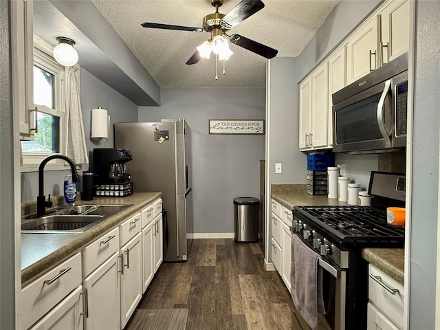 205 E Livingston Ave, Des Moines, IA 50315 - kitchen featuring appliances with stainless steel finishes, a textured ceiling, dark wood-style floors, ceiling fan, and white cabinets