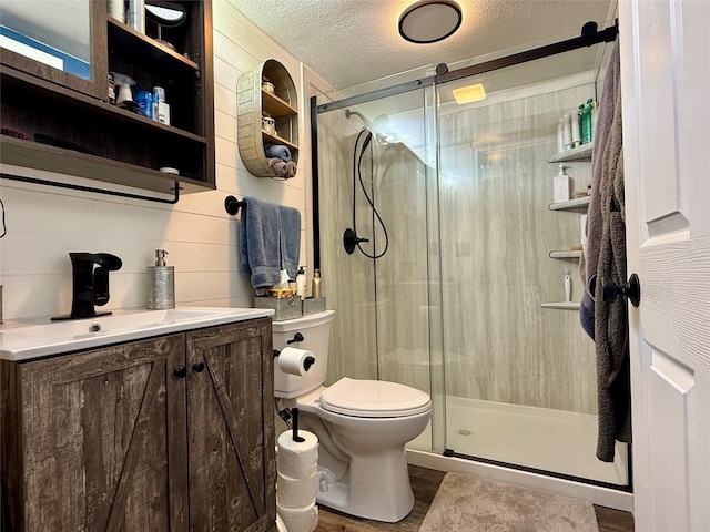 205 E Livingston Ave, Des Moines, IA 50315 - bathroom with vanity, a textured ceiling, a shower stall, and wood finished floors
