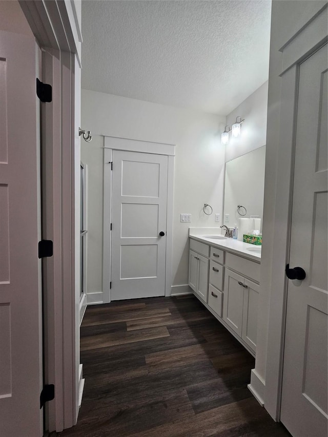 1108 28th St, Perry, IA 50220 - full bathroom with wood finished floors, double vanity, a textured ceiling, and an enclosed shower