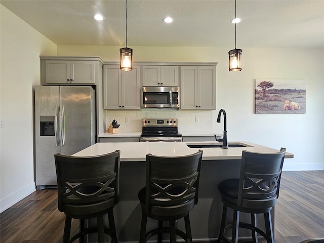 1108 28th St, Perry, IA 50220 - kitchen with appliances with stainless steel finishes, gray cabinetry, decorative backsplash, dark wood-style flooring, and recessed lighting