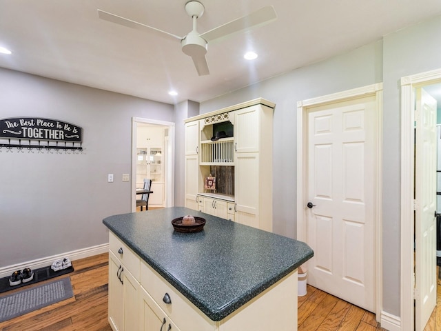 310 Greene St, Boone, IA 50036 - kitchen featuring light wood-style floors, dark countertops, recessed lighting, a kitchen island, and white cabinetry