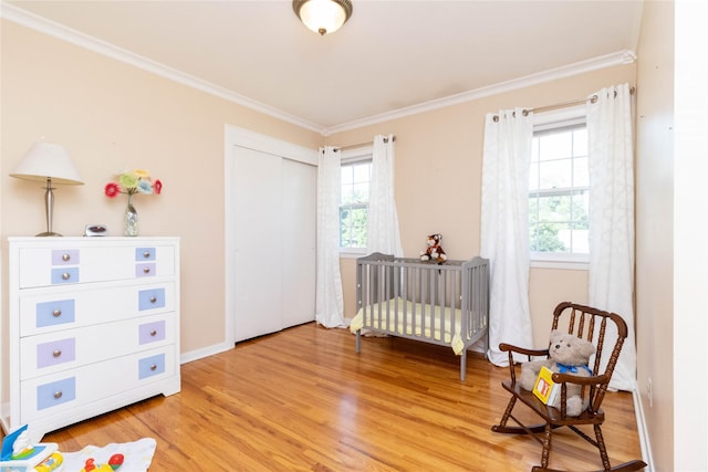 1809 79th St, Windsor Heights, IA 50324 - bedroom featuring ornamental molding, light wood-type flooring, and a closet