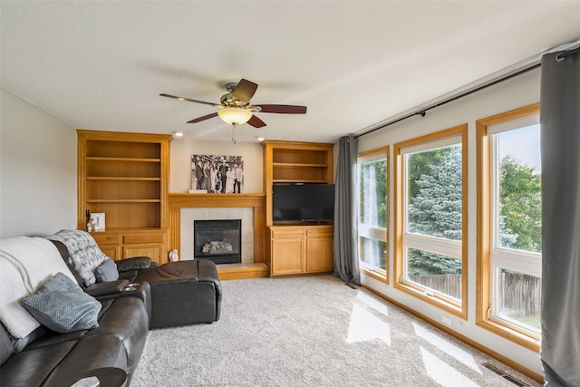4380 Ashley Park Dr, West Des Moines, IA 50265 - living room with light colored carpet, a tile fireplace, a ceiling fan, and built in shelves