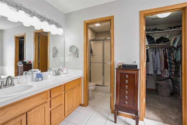 4380 Ashley Park Dr, West Des Moines, IA 50265 - bathroom featuring double vanity, a stall shower, a spacious closet, and tile patterned floors