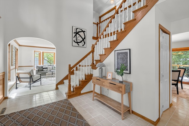 904 54th St, West Des Moines, IA 50266 - stairs featuring arched walkways, healthy amount of natural light, a towering ceiling, and tile patterned floors