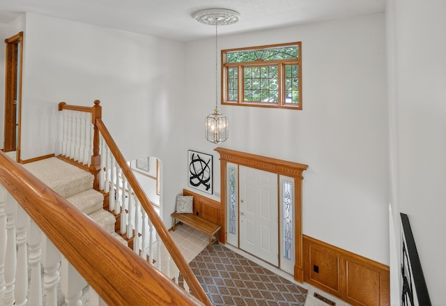 904 54th St, West Des Moines, IA 50266 - foyer featuring a chandelier, stairs, and wainscoting