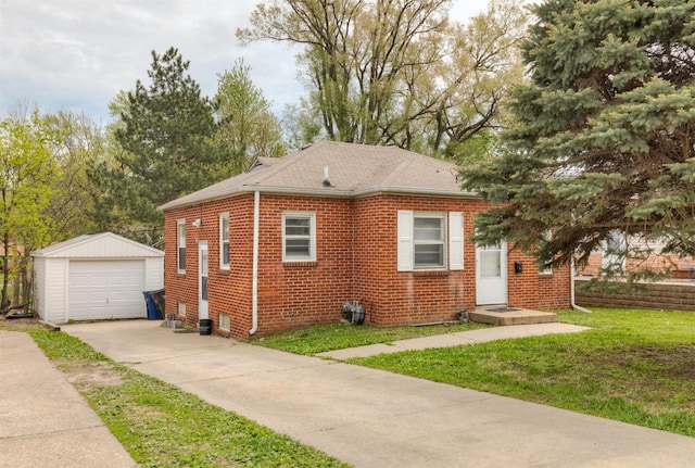 4115 11th St, Des Moines, IA 50313 - view of front of home featuring driveway, an outbuilding, brick siding, a garage, and a front yard