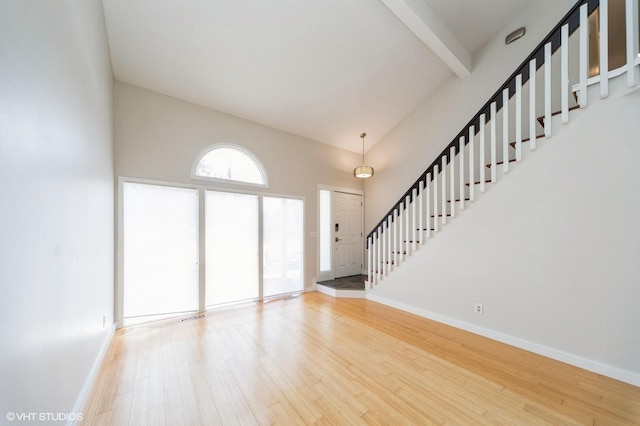 2729 Meadow Point Ct, West Des Moines, IA 50265 - unfurnished living room featuring wood finished floors, stairs, beam ceiling, and a towering ceiling