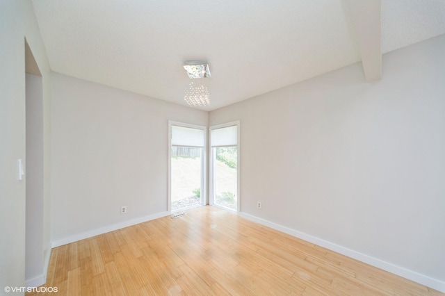 2729 Meadow Point Ct, West Des Moines, IA 50265 - empty room with light wood finished floors and a chandelier