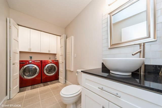 2729 Meadow Point Ct, West Des Moines, IA 50265 - bathroom with washer and clothes dryer, vanity, a textured ceiling, backsplash, and tile patterned floors