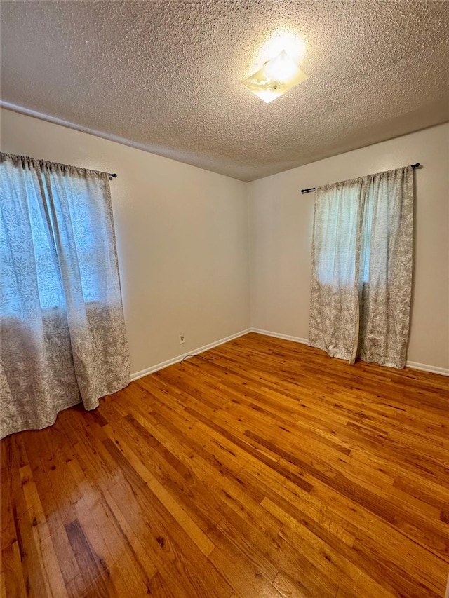 2611 E 38th St, Des Moines, IA 50317 - spare room with wood-type flooring and a textured ceiling