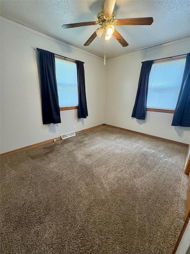 2611 E 38th St, Des Moines, IA 50317 - empty room featuring carpet, plenty of natural light, a ceiling fan, a textured ceiling, and ornamental molding