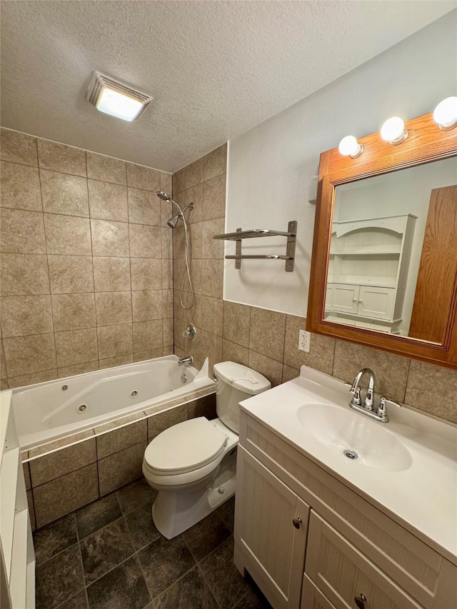 2611 E 38th St, Des Moines, IA 50317 - bathroom featuring a combined bath / shower with jetted tub, tile walls, vanity, and a textured ceiling