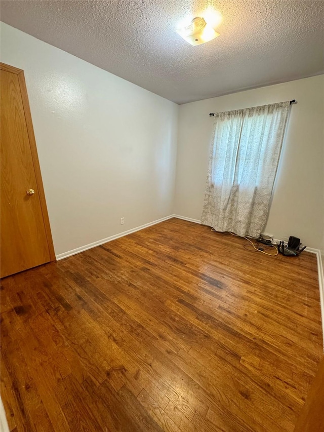 2611 E 38th St, Des Moines, IA 50317 - unfurnished room featuring wood-type flooring and a textured ceiling
