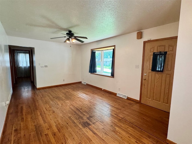 2611 E 38th St, Des Moines, IA 50317 - unfurnished room with ceiling fan, hardwood / wood-style flooring, and a textured ceiling