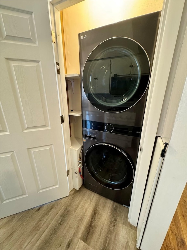 2611 E 38th St, Des Moines, IA 50317 - laundry area featuring stacked washer and clothes dryer and wood finished floors