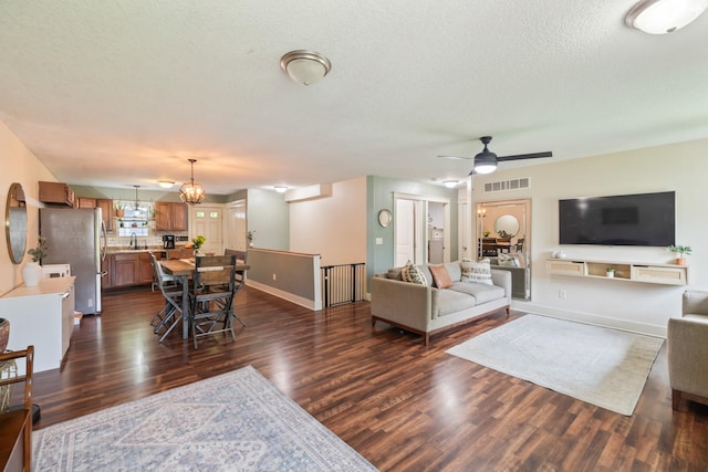 4034 6th Ave, Des Moines, IA 50313 - living room featuring dark wood-style flooring, a ceiling fan, and a textured ceiling