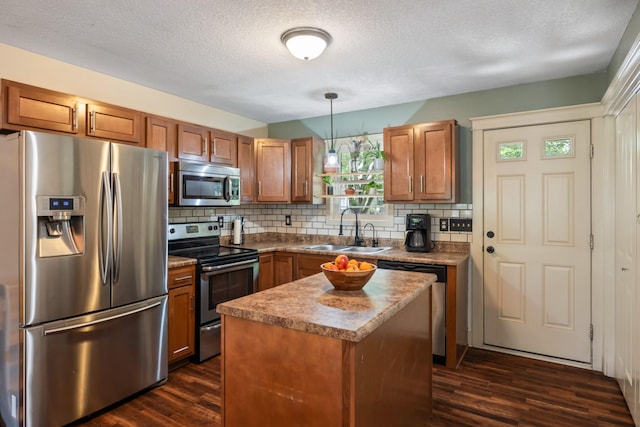4034 6th Ave, Des Moines, IA 50313 - kitchen with stainless steel appliances, dark wood-type flooring, backsplash, brown cabinets, and a textured ceiling