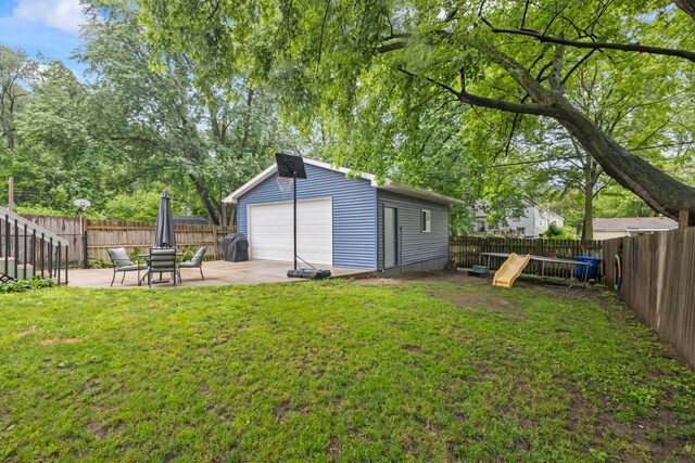 4034 6th Ave, Des Moines, IA 50313 - fenced backyard with a detached garage, an outdoor structure, and a patio area