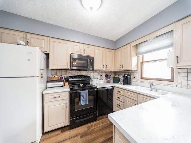 401 NW Valley View Dr, Grimes, IA 50111 - kitchen with black appliances, wood finished floors, light countertops, tasteful backsplash, and a textured ceiling