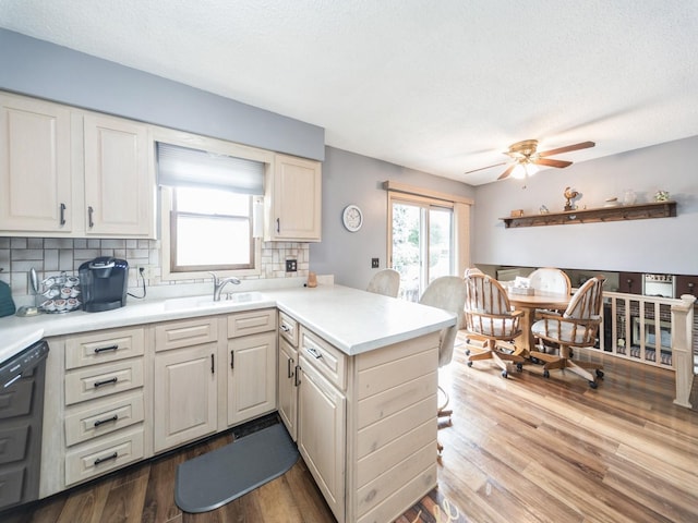 401 NW Valley View Dr, Grimes, IA 50111 - kitchen featuring a peninsula, decorative backsplash, a ceiling fan, light countertops, and wood finished floors