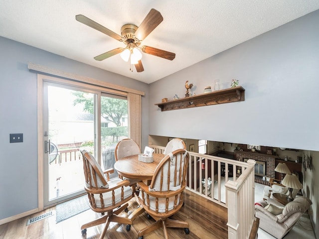 401 NW Valley View Dr, Grimes, IA 50111 - dining space with wood finished floors, ceiling fan, and a brick fireplace