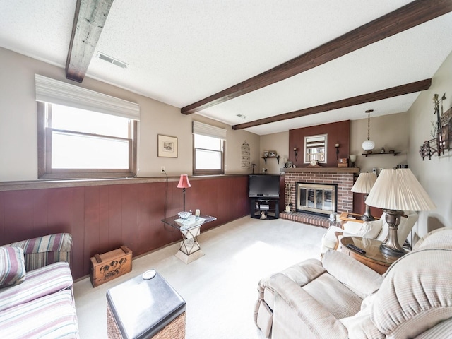 401 NW Valley View Dr, Grimes, IA 50111 - carpeted living area featuring beamed ceiling, a brick fireplace, a wainscoted wall, wood walls, and a textured ceiling