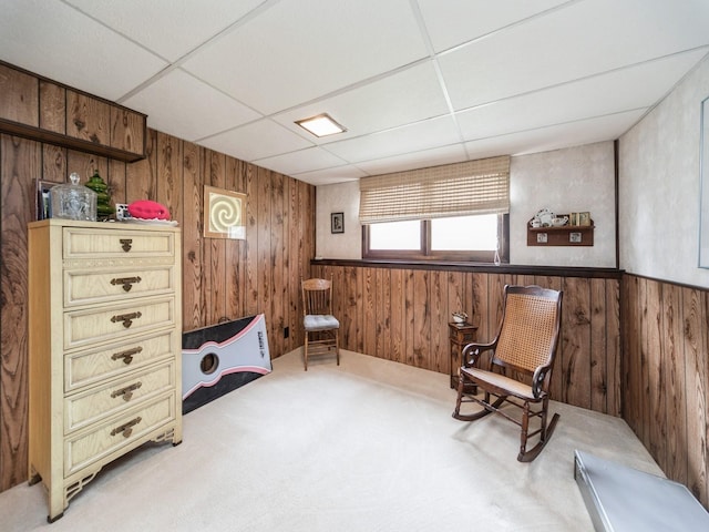 401 NW Valley View Dr, Grimes, IA 50111 - living area featuring wooden walls, a paneled ceiling, light colored carpet, and wainscoting