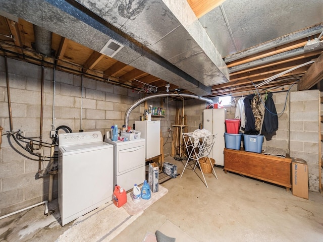 401 NW Valley View Dr, Grimes, IA 50111 - unfinished basement featuring separate washer and dryer, water heater, and freestanding refrigerator
