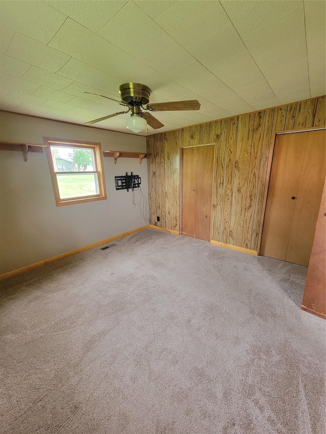 108 W Logan St, Casey, IA 50048 - unfurnished room featuring carpet floors, wood walls, and ceiling fan