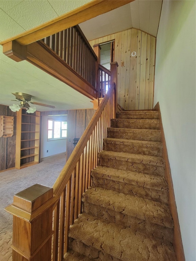 108 W Logan St, Casey, IA 50048 - stairs featuring vaulted ceiling, wood walls, ceiling fan, and carpet floors