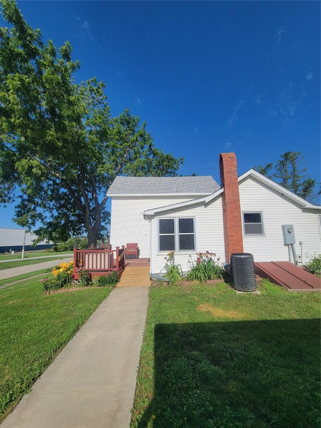 108 W Logan St, Casey, IA 50048 - view of property exterior featuring a deck, a lawn, a chimney, and a shingled roof
