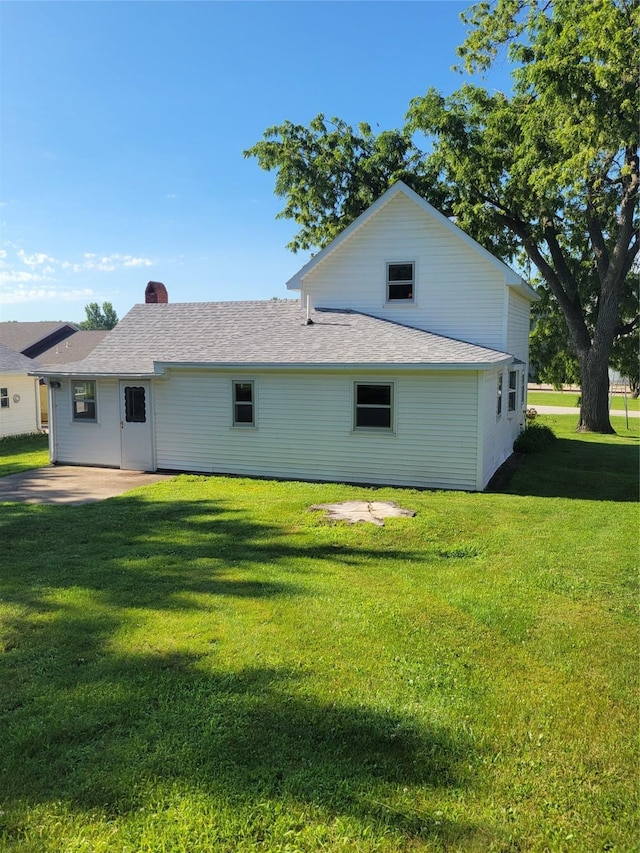 108 W Logan St, Casey, IA 50048 - back of property with a lawn, a shingled roof, and a chimney