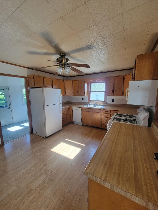 108 W Logan St, Casey, IA 50048 - kitchen featuring white appliances, light wood-style floors, brown cabinetry, light countertops, and a ceiling fan