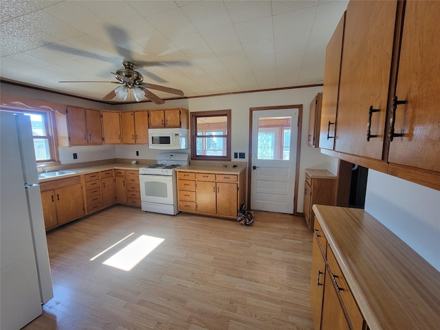 108 W Logan St, Casey, IA 50048 - kitchen featuring white appliances, light wood-style floors, light countertops, brown cabinetry, and ceiling fan