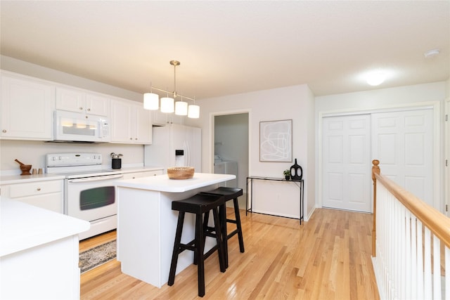 7316 SE 23rd St Unit 5, Des Moines, IA 50320 - kitchen featuring white appliances, washing machine and dryer, light wood-type flooring, and light countertops