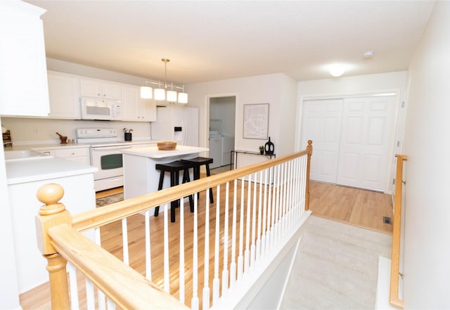 7316 SE 23rd St Unit 5, Des Moines, IA 50320 - corridor featuring an upstairs landing, washer and dryer, and light wood finished floors