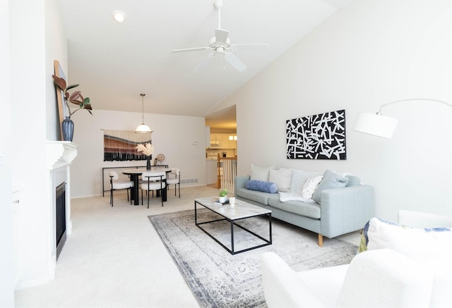 7316 SE 23rd St Unit 5, Des Moines, IA 50320 - living area with vaulted ceiling, a ceiling fan, carpet flooring, and a fireplace