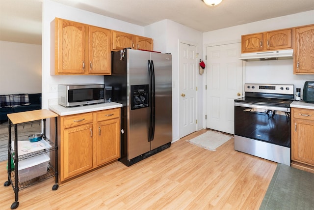 2609 Eagle Point Ct, Des Moines, IA 50320 - kitchen featuring appliances with stainless steel finishes, under cabinet range hood, light wood-style floors, and light countertops