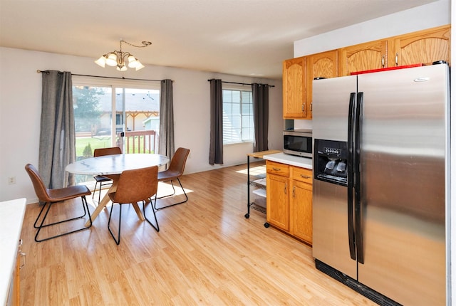 2609 Eagle Point Ct, Des Moines, IA 50320 - kitchen featuring stainless steel appliances, a chandelier, light wood-style floors, and light countertops